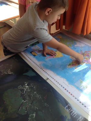 Ein Schüler sucht Deutschland auf einer Weltkarte im Rahmen des Projekts PrimaKlimaKids