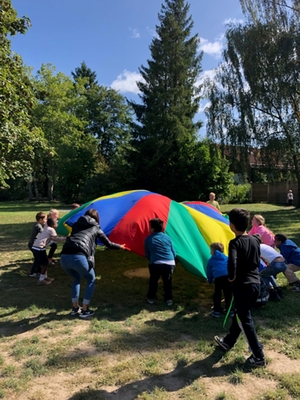 Kinder spielen mit einem Farbtuch am Wandertag 1. Klassen