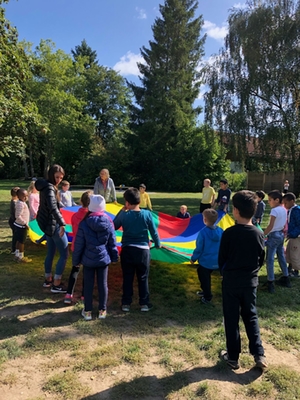 Kinder spielen mit einem Farbtuch am Wandertag 1. Klassen