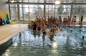 Kinder auf dem Weg ins Wasser in der Schulschwimmhalle