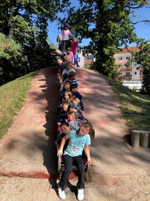 Beim Wandertag 3. Klassen sitzen alle Schüler auf der Rutsche eines Spielplatzes